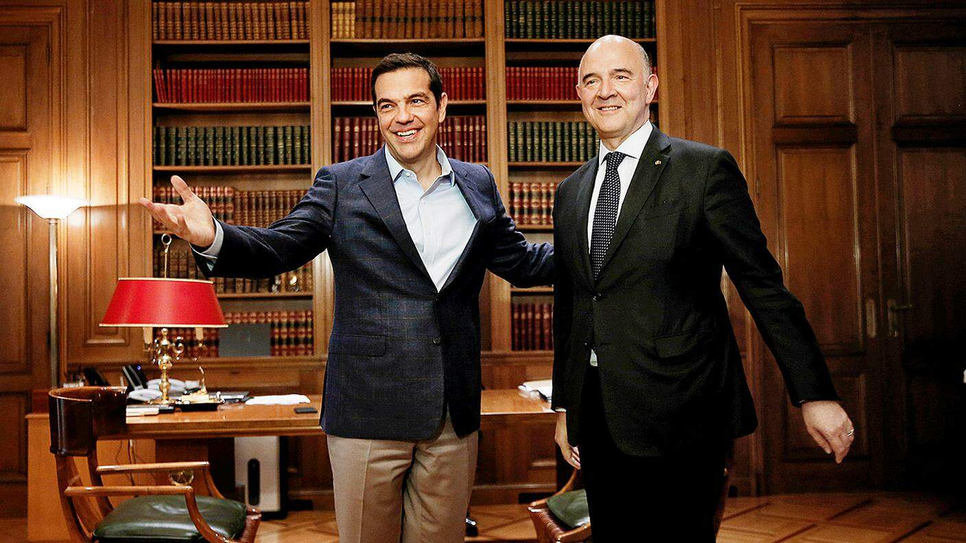 Il primo ministro greco Alexis Tsipras e, a destra, Pierre Moscovici, commissario europeo per gli affari economici e monetari