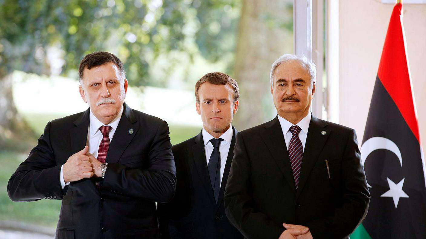 Il presidente francese Emmanuel Macron (al centro) con il presidente del Consiglio presidenziale di Tripoli, Fayez al Sarraj (a sinistra) e il comandante dell'esercito nazionale libico, Khalifa Haftar