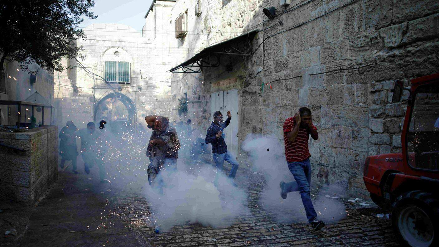 Dimostranti palestinesi fuggono dai fumogeni lanciati dagli agenti israeliani