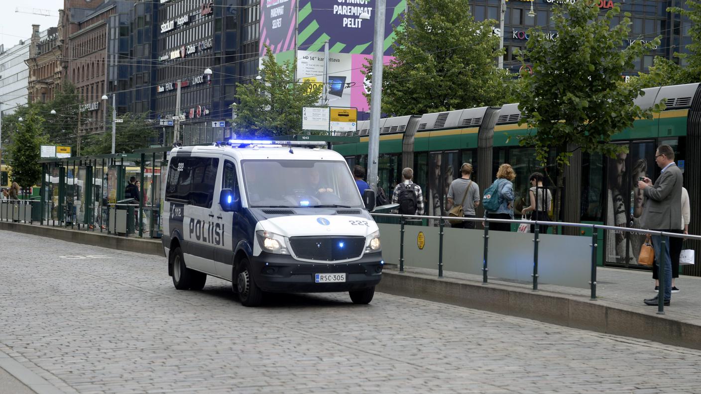 Un veicolo della polizia a sirene spiegate, nel centro della città