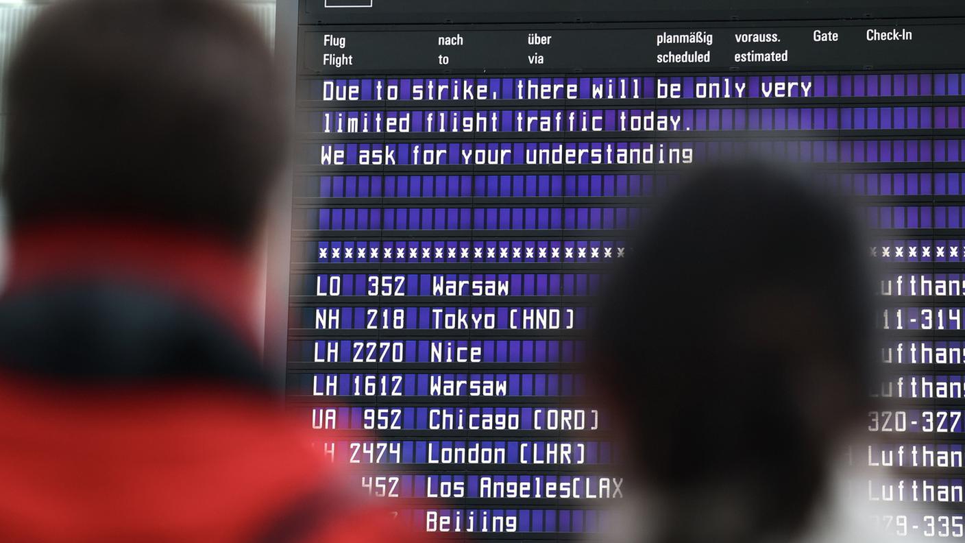 Passeggeri leggono le informazioni all'aeroporto di Monaco di Baviera in merito allo sciopero