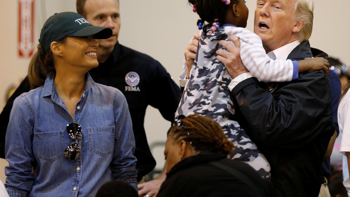 Donald Trump prende in braccio una piccola ospite del rifugio di Houston