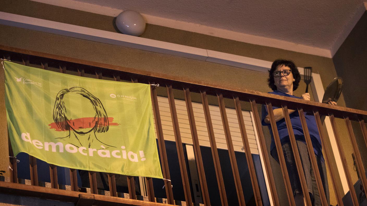 Una donna protesta sul balcone di casa a Barcellona