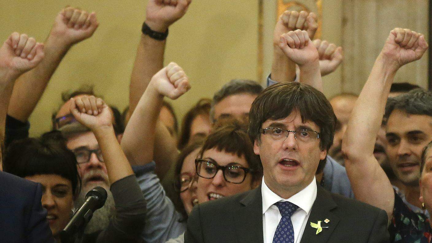 Puigdemont mentre canta l'inno catalano dopo il voto sull'indipendenza