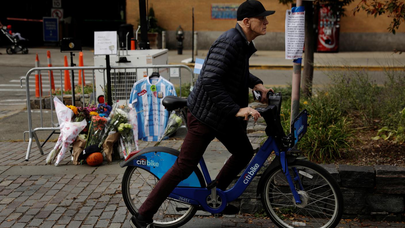 Un ciclista passa accanto a un ricordo per le vittime. Degli otto morti cinque erano argentini