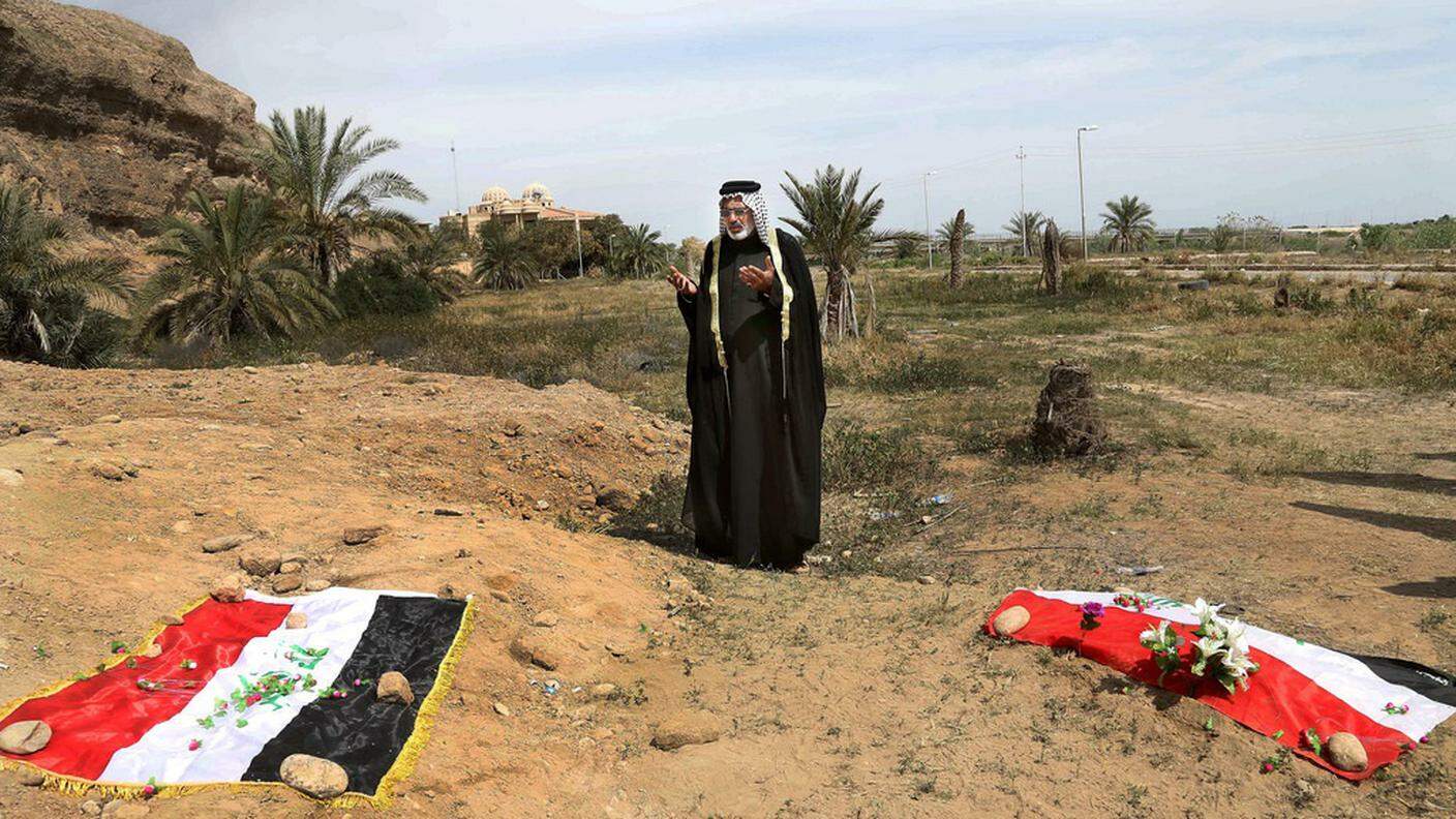 Immagine d'archivio: un uomo prega su una delle fosse comuni vicino a Tikrit