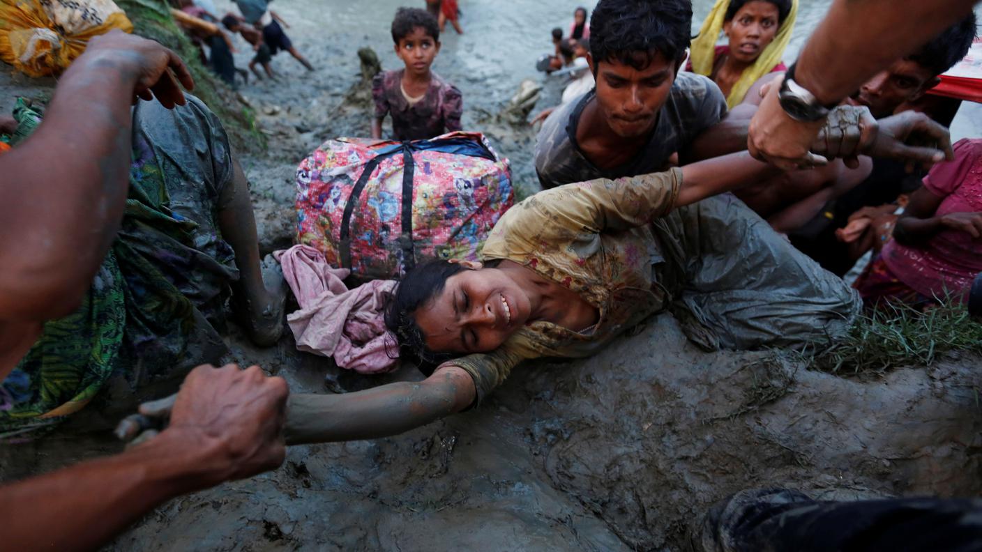 Una donna mentre sta attraversando il fiume che divide il Myanmar dal Bangladesh