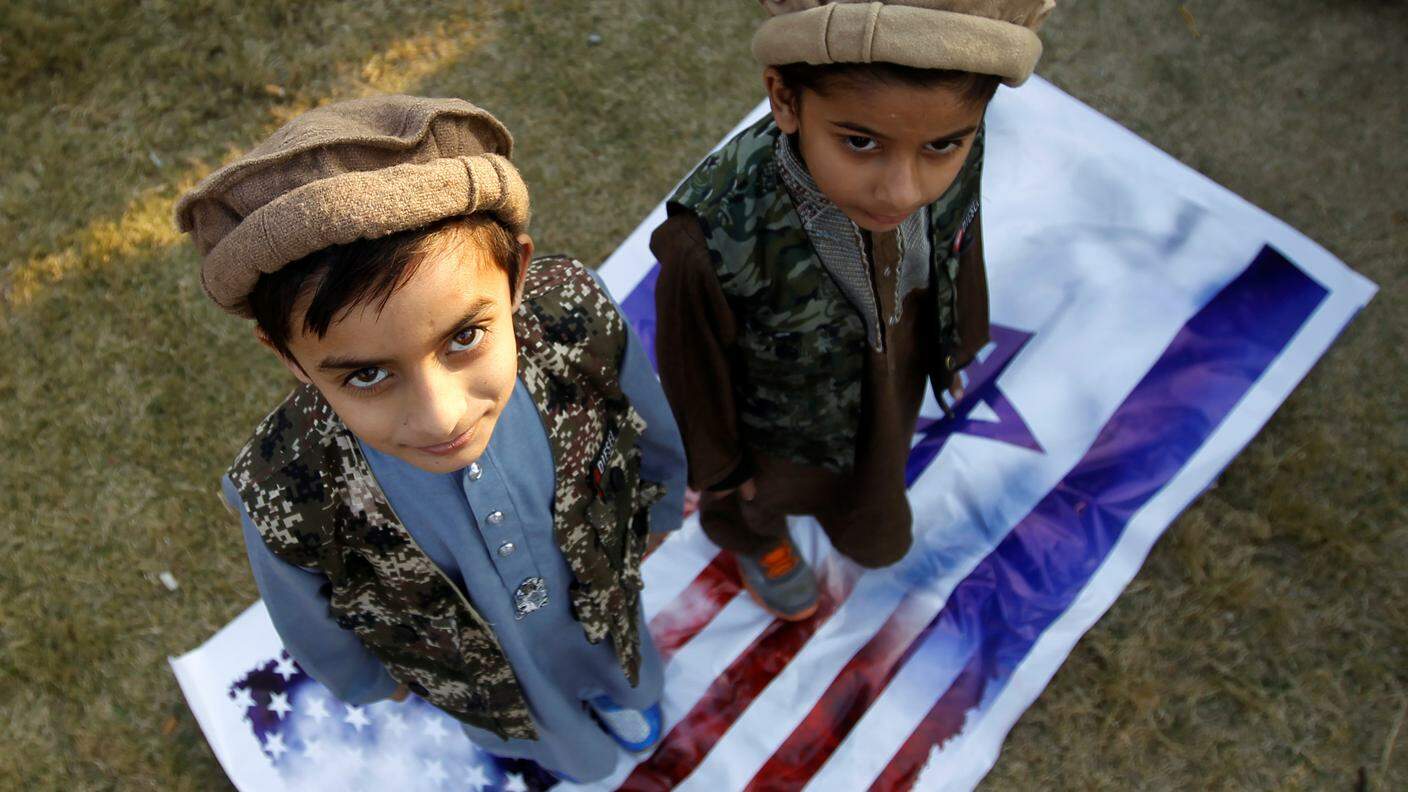 Bambini ad Islamabad in Pakistan calpestano bandiere israeliane e statunitensi
