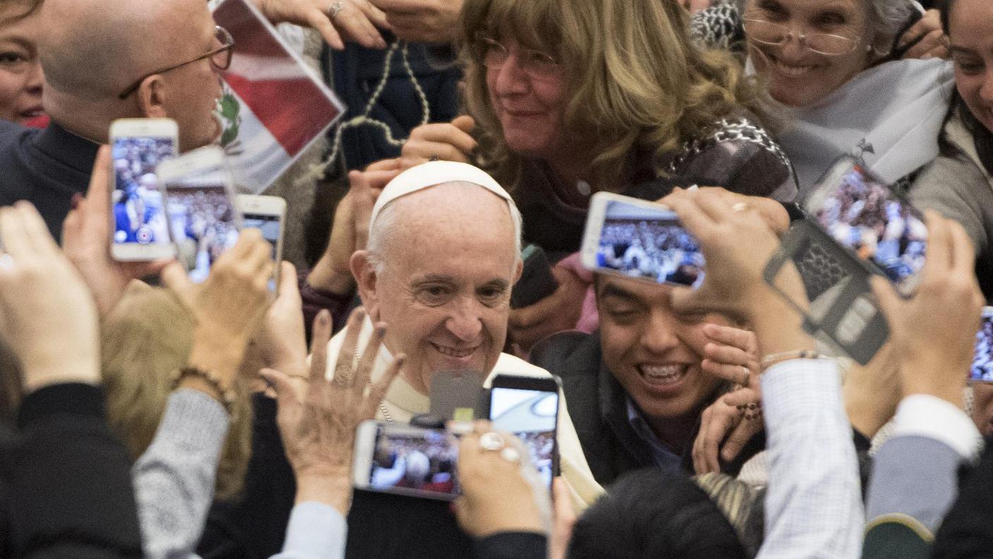 Papa Francesco circondato dall'affetto dei fedeli durante un'udienza in Vaticano