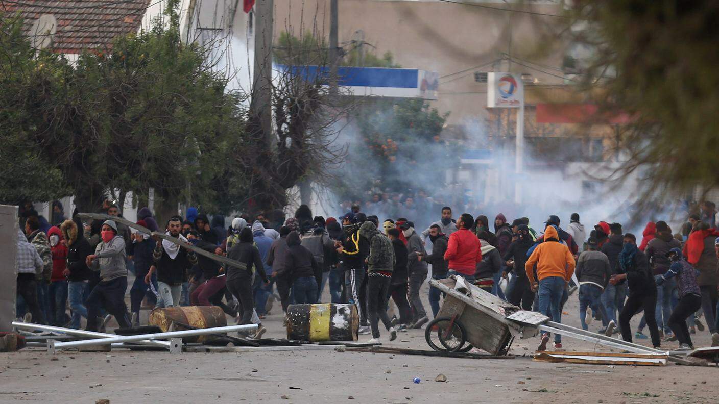 I manifestanti dispersi dai lacrimogeni dei poliziotti in una strada di Tebourba