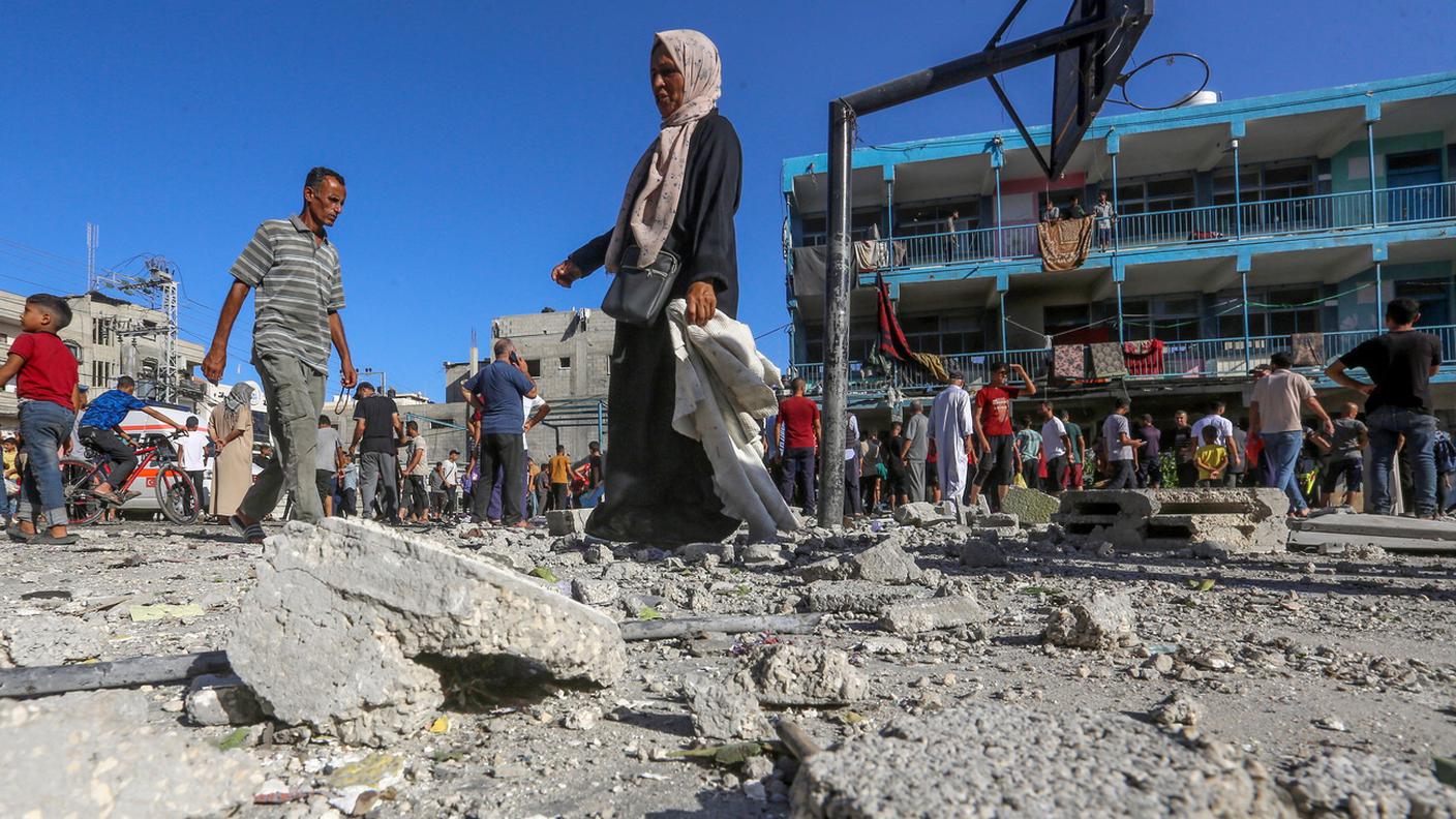 Palestinesi tra le macerie della scuola dell'UNRWA distrutta
