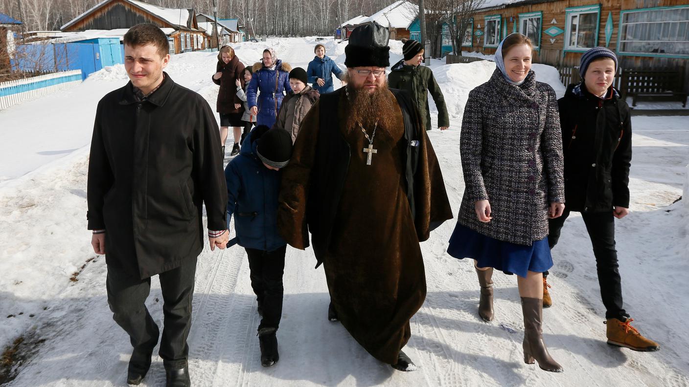 Il prete ortodosso Sergei Ryzhov con membri della sua famiglia mentre si reca alle urne in un villaggio siberiano