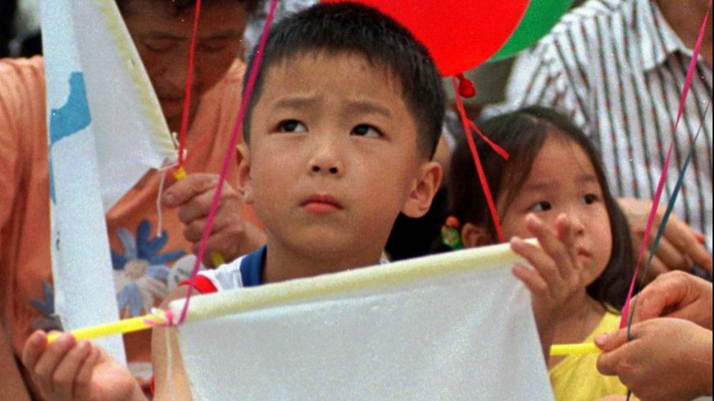 Un bimbo con la bandiera di riunificazione coreana: le prove di dialogo fanno sperare