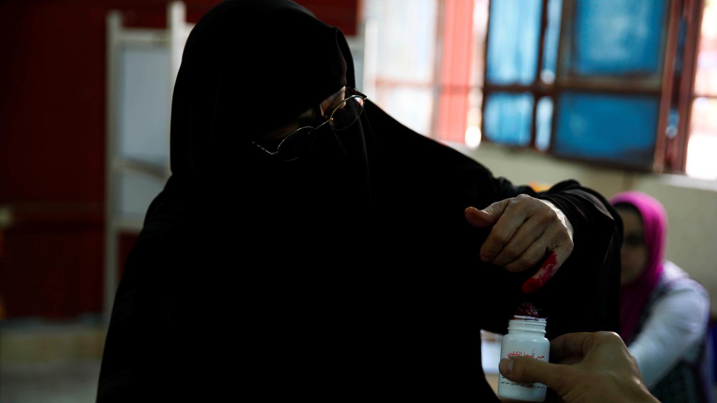 Una donna fotografata al Cairo mentre intinge il dito nell'inchiostro durante la procedura di voto