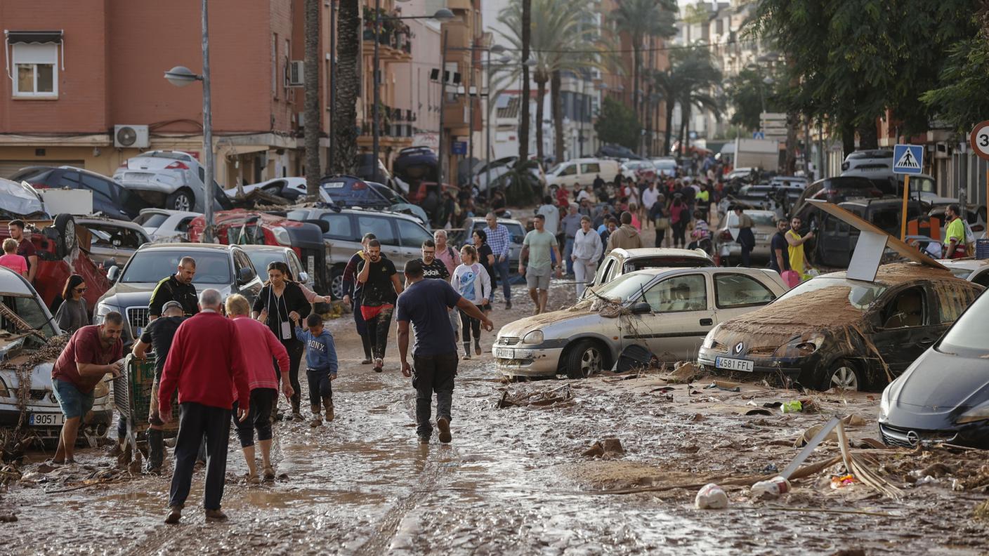 I residenti lungo una strada coperta di fango a Paiporta
