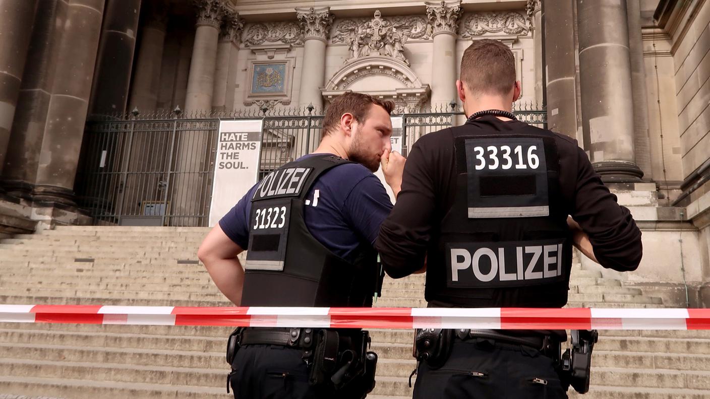 Due poliziotti tedeschi davanti a una scalinata del duomo di Berlino domenica pomeriggio