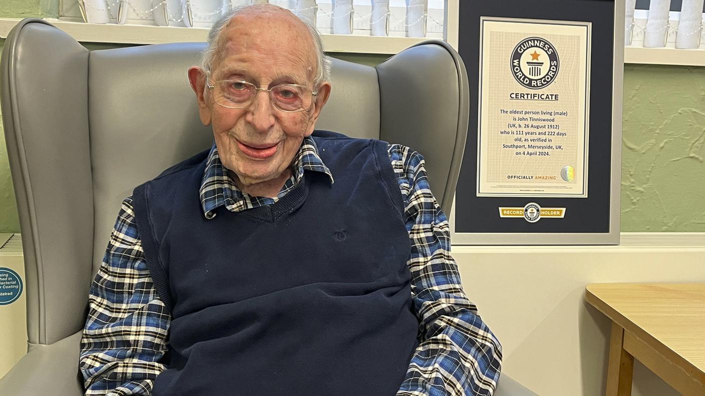 John Alfred Tinniswoods, in posa lo scorso aprile, con il certificato del Guinness dei primati.jpg