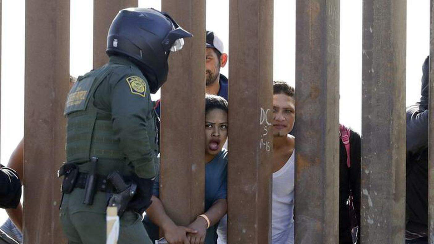 Migranti al muro di confine con gli USA