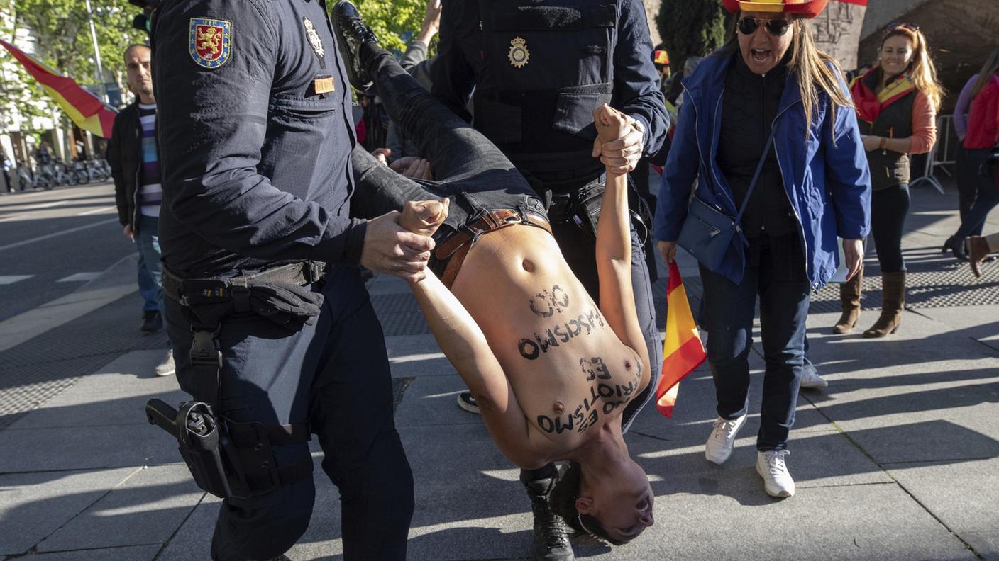Una delle Femen trascinata via dalla polizia