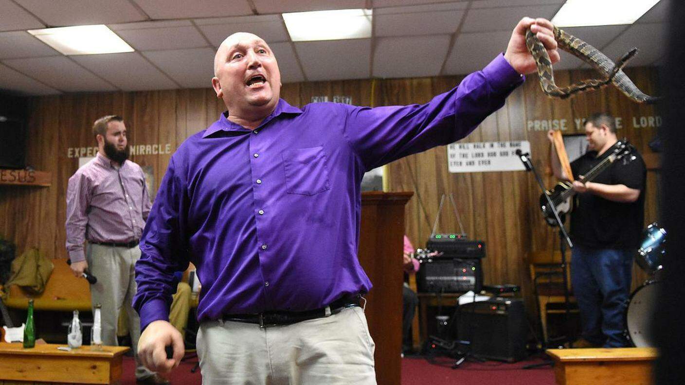 Il pastore pentecostale Chris Wolford maneggia un serpente a sonagli durante un rito religioso a Squire, in West Virginia