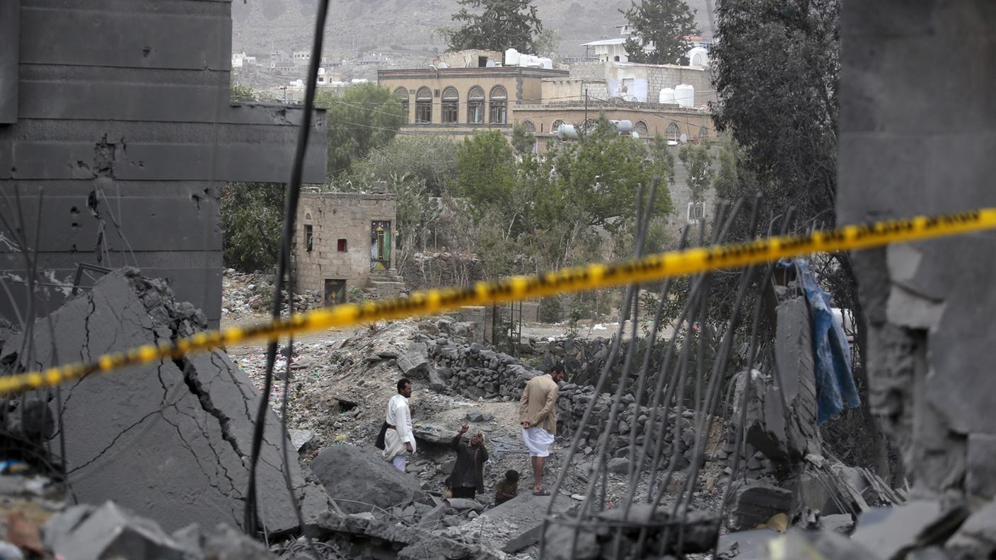 Un uomo ispeziona i danni intorno a un edificio dopo gli attacchi aerei statunitensi a Sanaa di lunedì