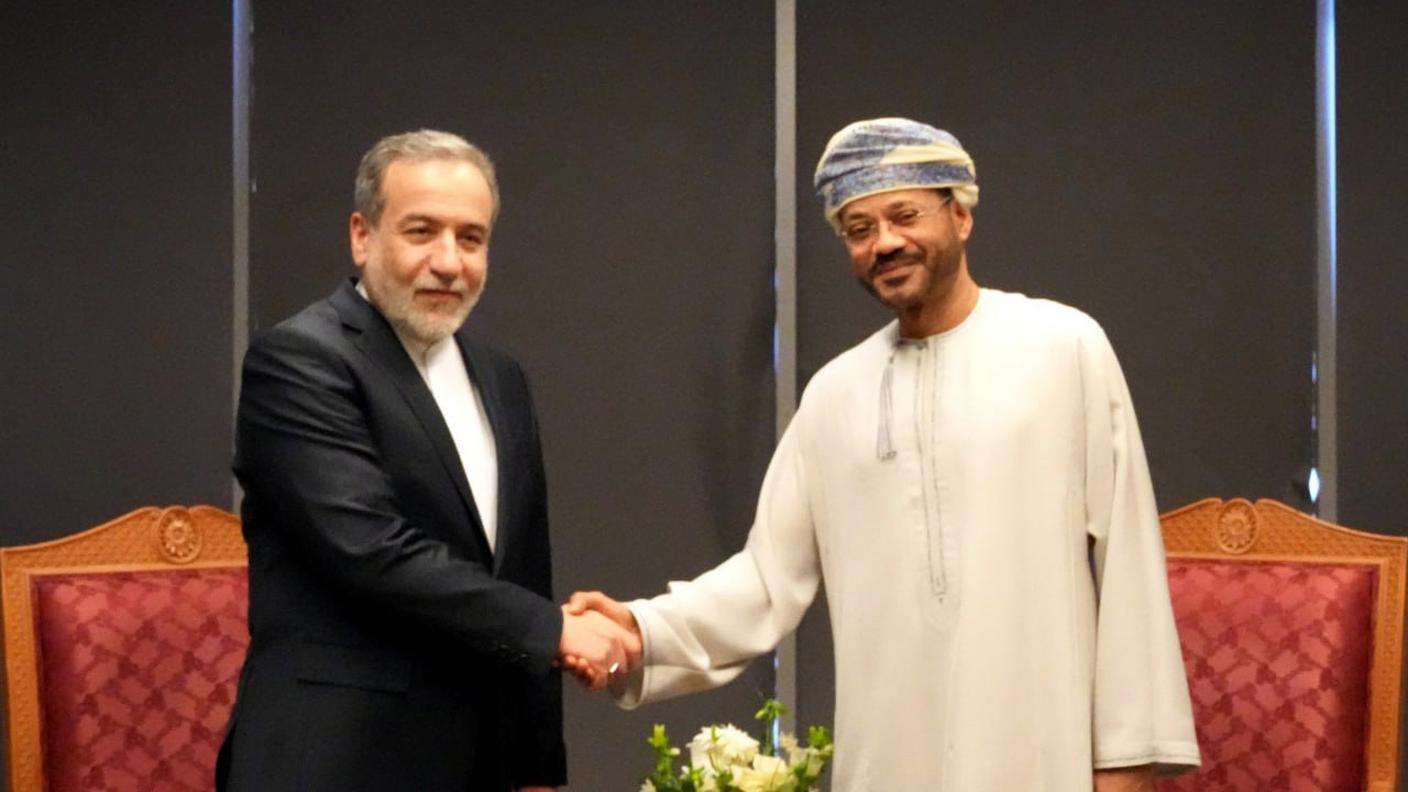 Il ministro iraniano Abbas Araghchi stringe la mano al mediatore, il ministro omanita, Badr bin Hamad al-Busaidi