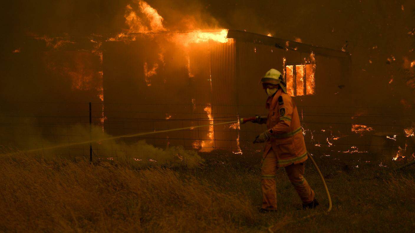 Un pompiere cerca di domare un incendio sulle Blue Mountains, a ovest di Sydney 