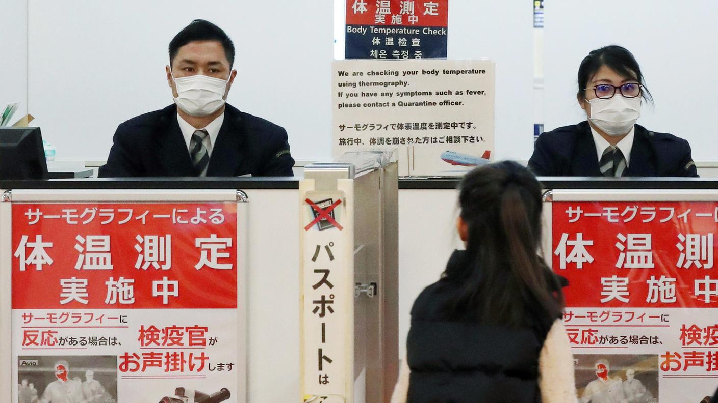 Una passeggera passa i controlli di quarantena all'aeroporto di Narita, in Giappone