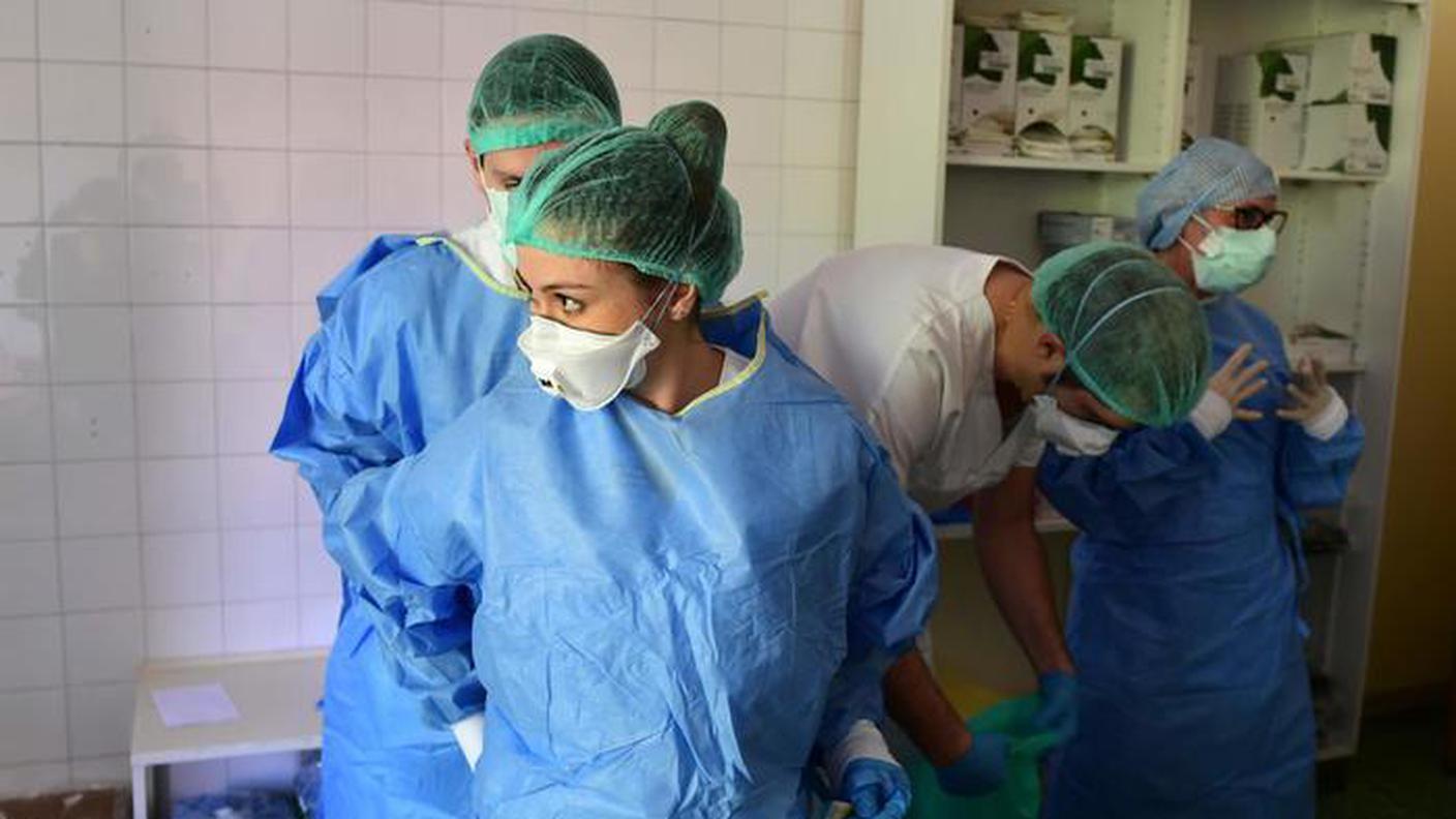 Un medico si prepara con la tuta anti-contagio