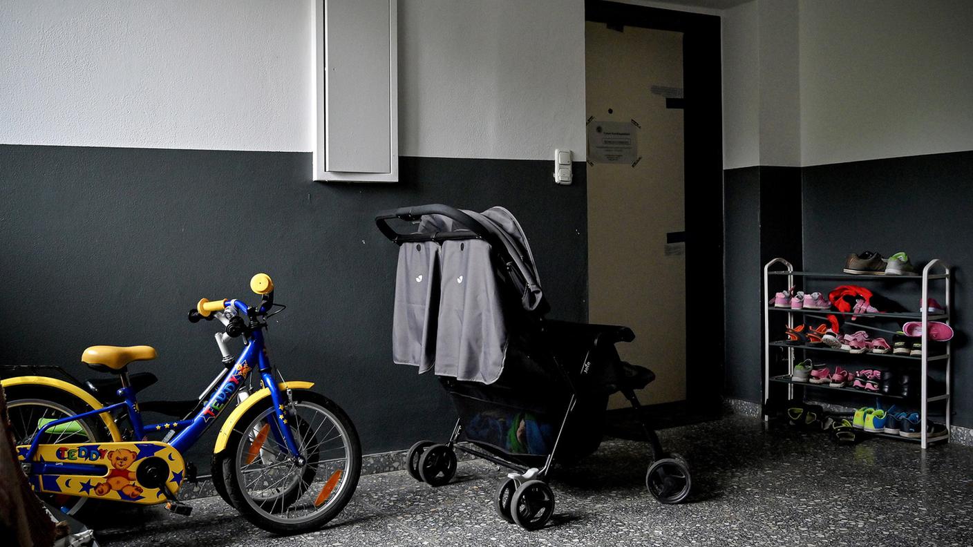 Scarpe, biciclette e passeggino davanti all'appartamento dove sono stati trovati i corpi