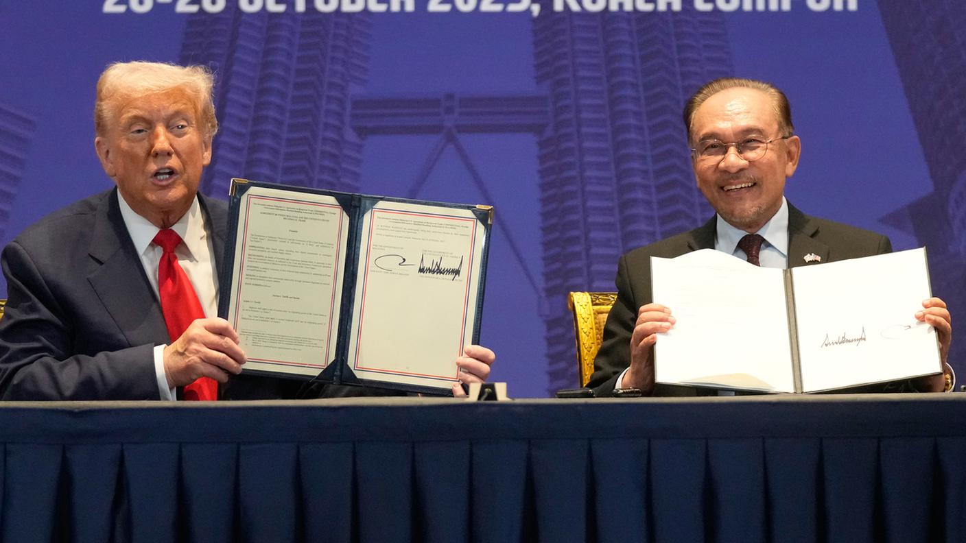 Il presidente USA Donald Trump e il premier malese Anwar Ibrahim mostrano i documenti firmati