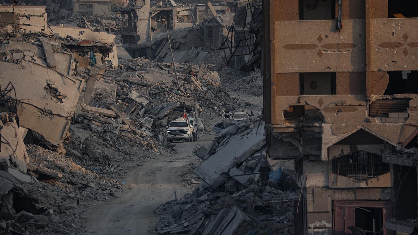 Gli operatori della Croce Rossa assistono i combattenti delle Brigate Al-Qassam, ala militare di Hamas, nella ricerca dei corpi degli ostaggi israeliani. Quartiere di Al Shejaeiya, Gaza City, 5 novembre 2025