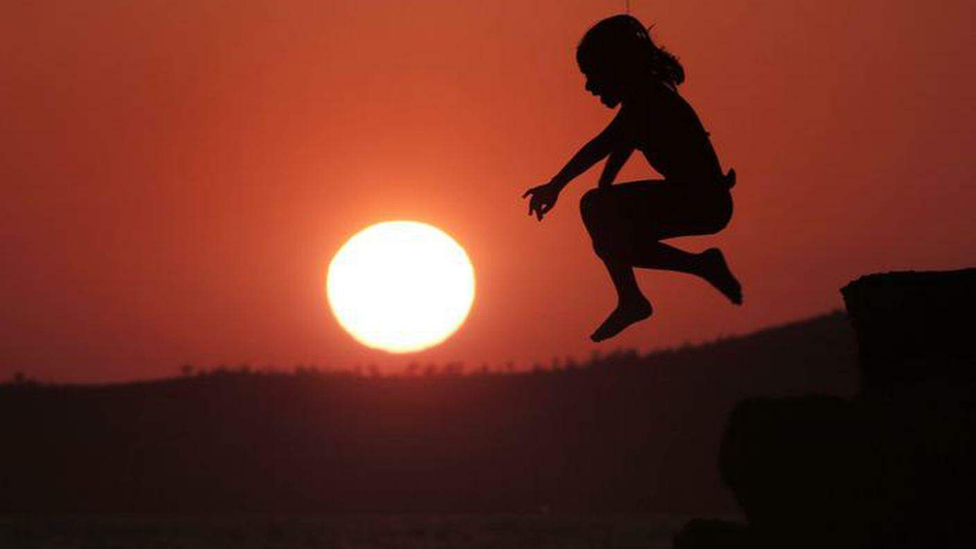 Una ragazza salta al tramonto ad Atene