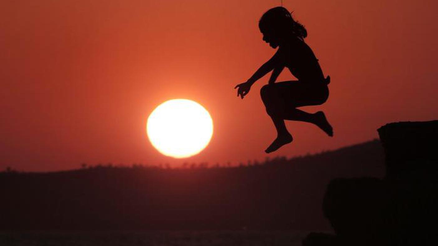 Una ragazza salta al tramonto ad Atene