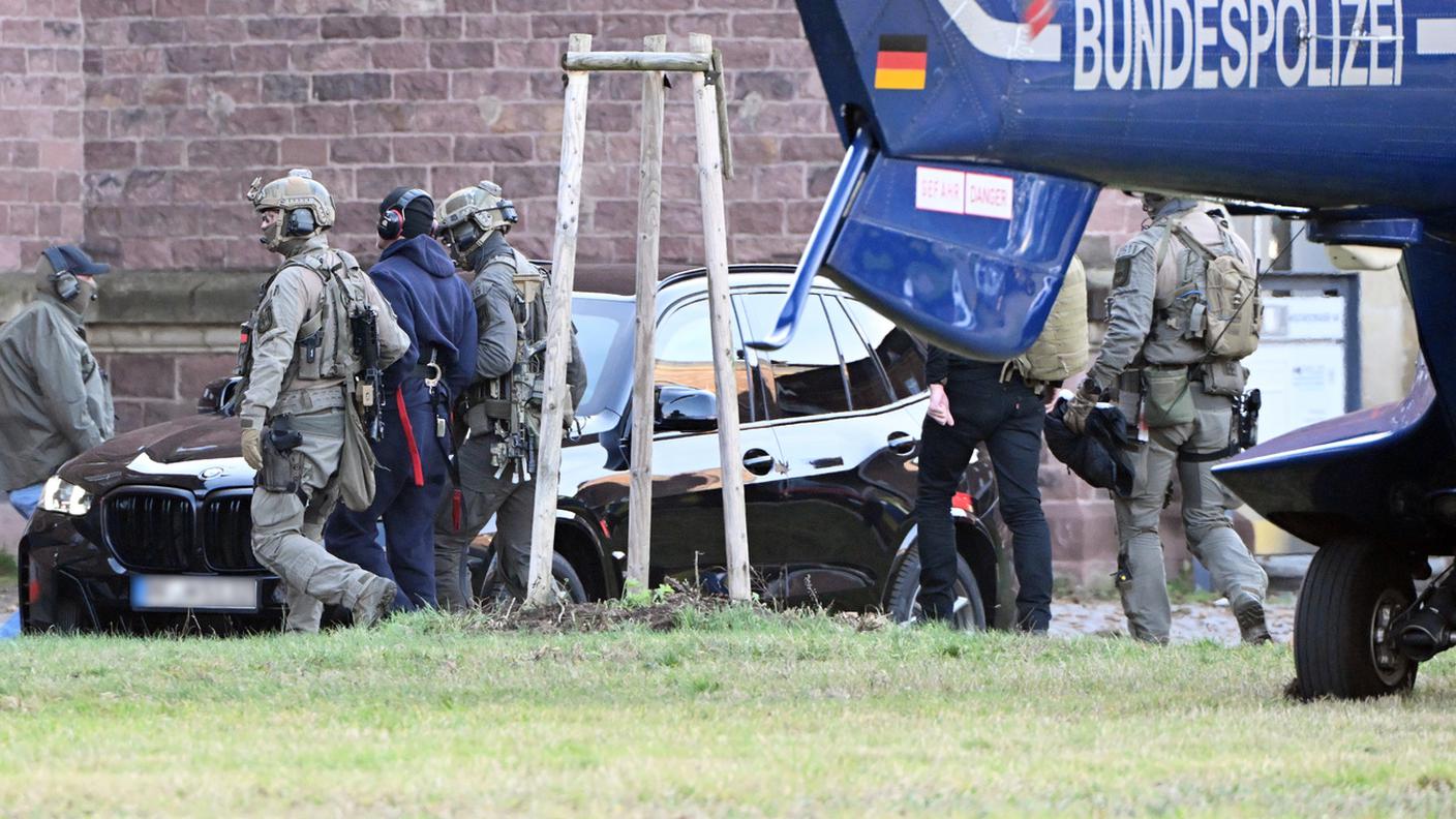 Gli agenti della polizia federale accompagnano il sospettato ucraino fuori dall'elicottero per la sua convocazione presso la Corte Suprema Federale a Karlsruhe