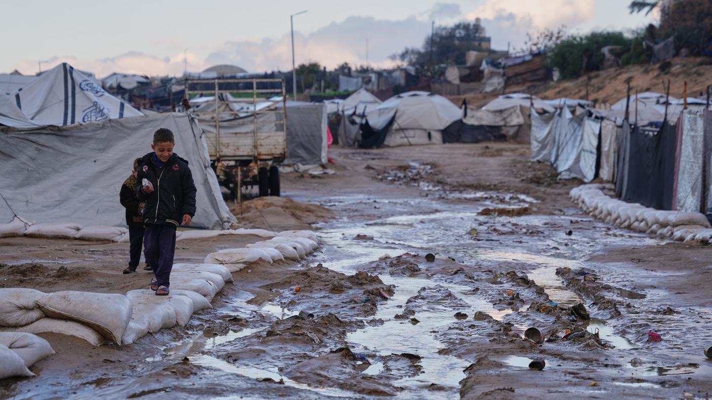 Un bambino palestinese cammina nel fango a Zawaida