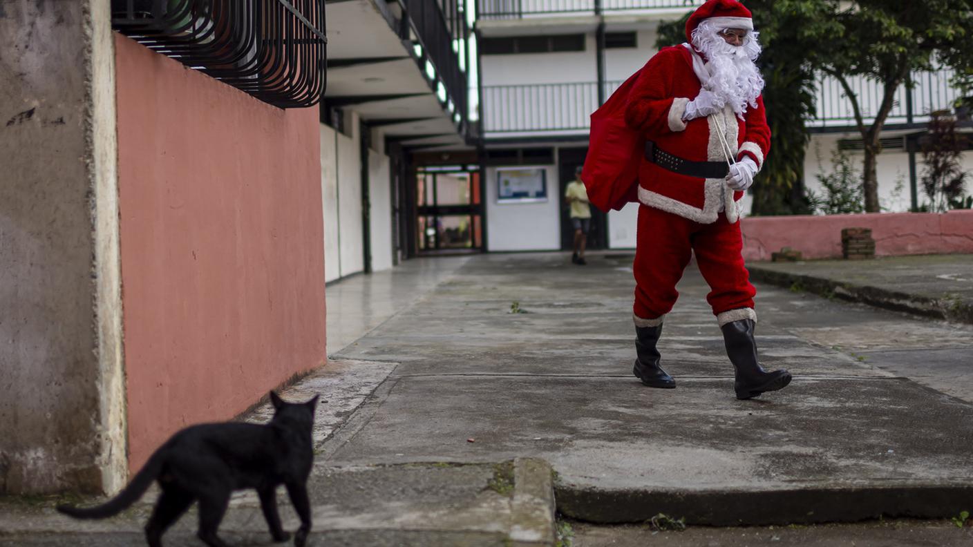 Un uomo vestito da Babbo Natale cammina nel quartiere operaio di La Dolorita a Caracas