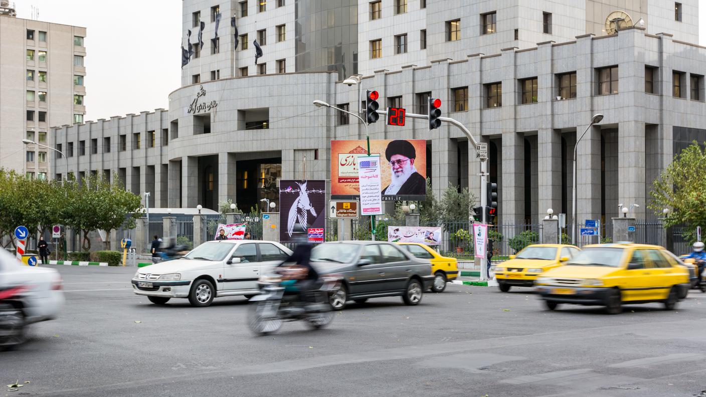 Veduta stradale nel centro di Teheran con un poster di Ali Khamenei.