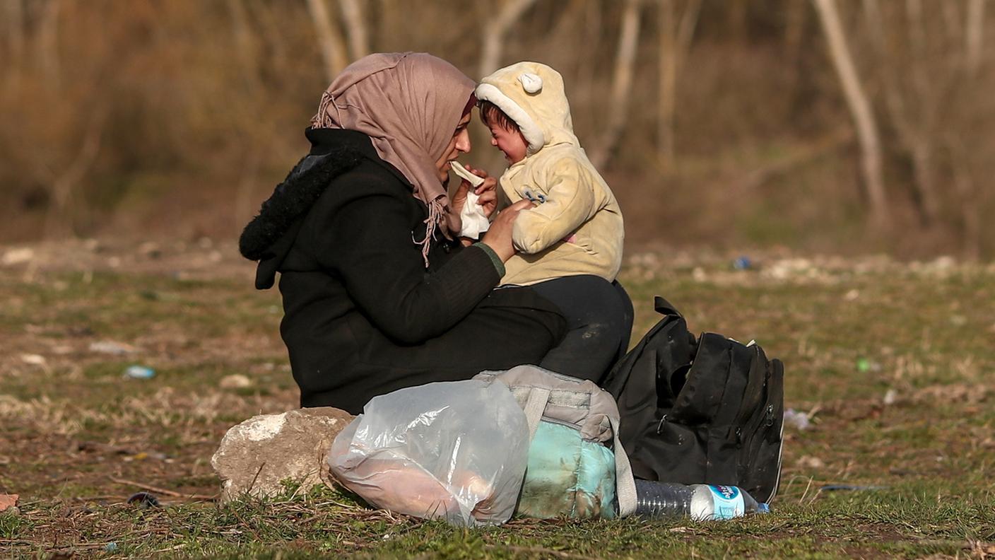 Una migrante con il suo bambino vicino al fiume Meric (Evros) al confine turco-greco, a Edirne, Turchia, 2 marzo 2020