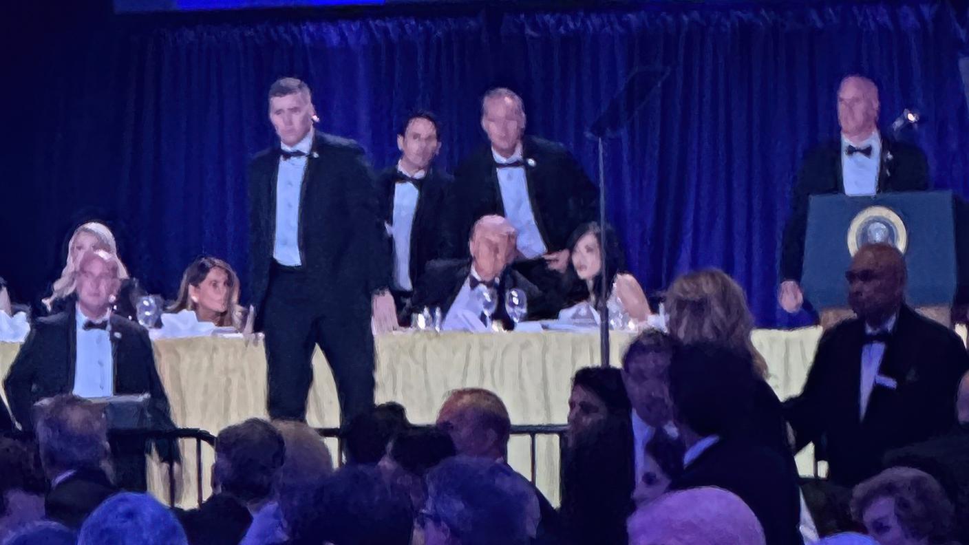 Agenti dei servizi segreti statunitensi circondano il presidente Donald Trump prima che venga portato via dal palco in seguito alla sparatoria avvenuta fuori dalla sala da ballo durante la cena dei corrispondenti della Casa Bianca