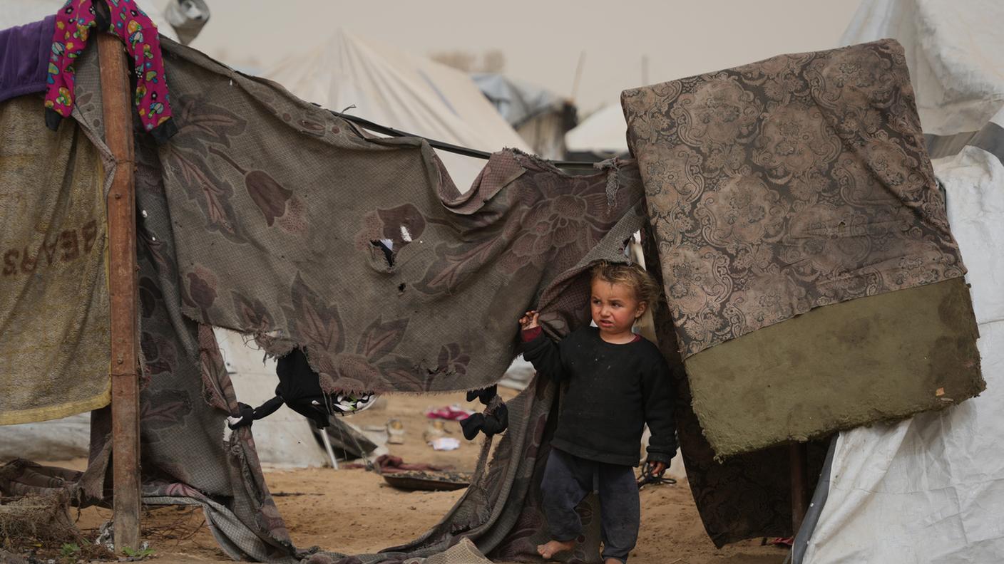 Un bimbo palestinese nel campo improvvisato per sfollati a Zawaida, Striscia di Gaza, 14 febbraio 2026