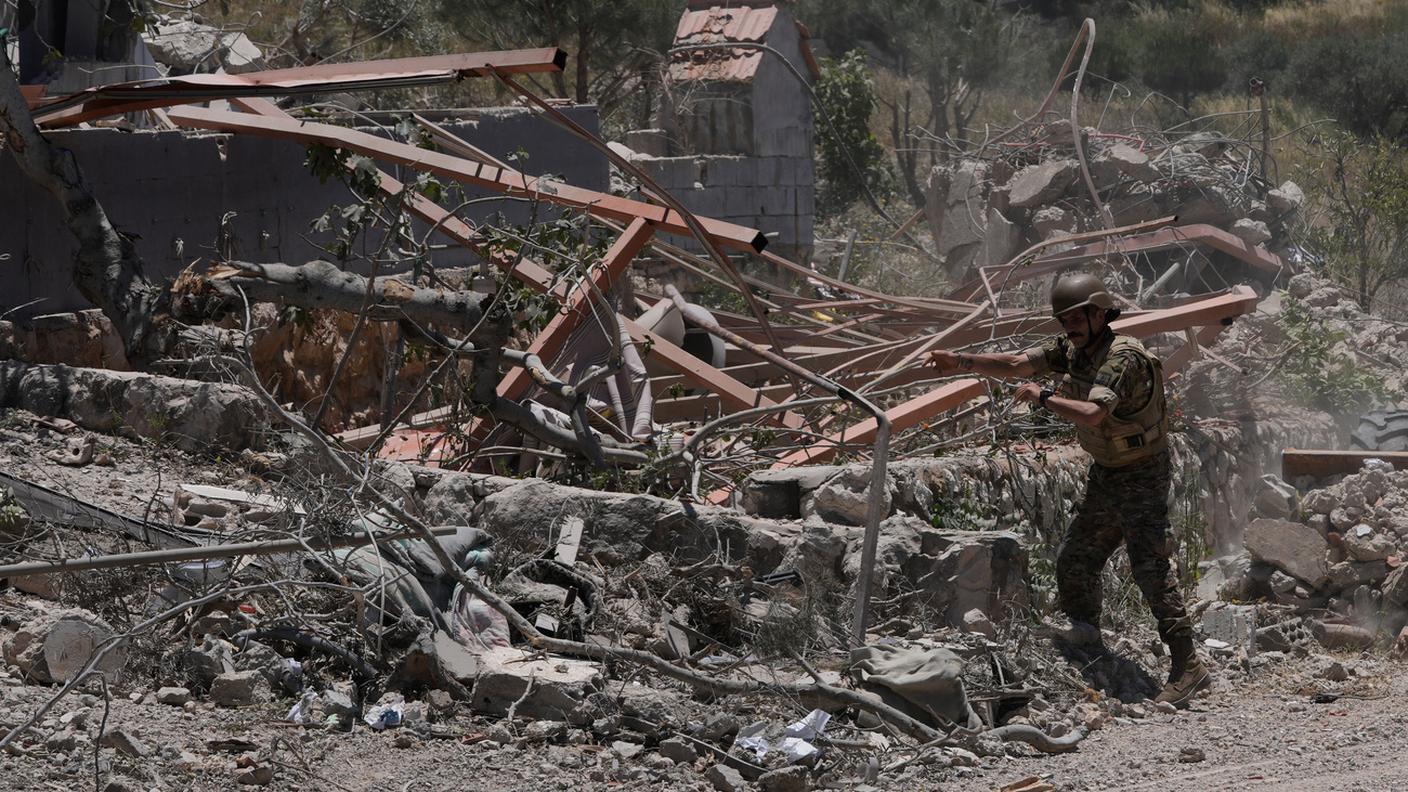 Un soldato libanese rimuove macerie in un villaggio devastato da un attacco israeliano nel sud del Paese