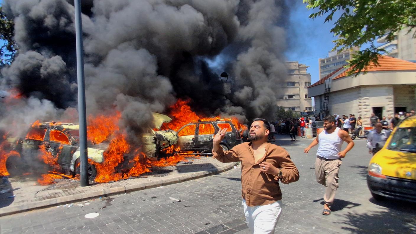 Auto in fiamme dopo un attacco aereo israeliano nel porto della città di Sidone, in Libano