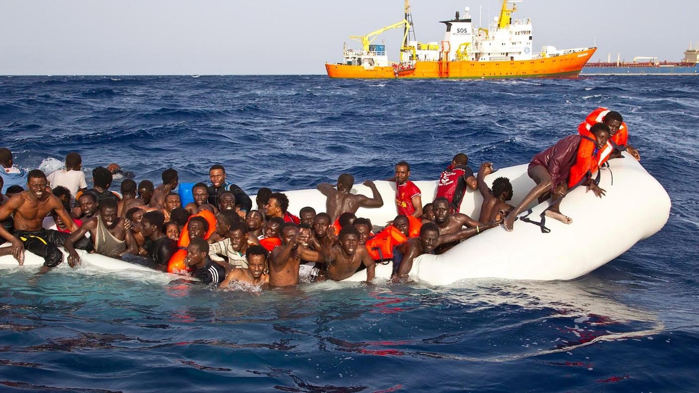 Alcuni migranti su un gommone che stava affondando, prima di essere soccorsi dalla nave Aquarius dell’organizzazione umanitaria SOS Méditerranée e condotti a Lampedusa, il 18 aprile 2016