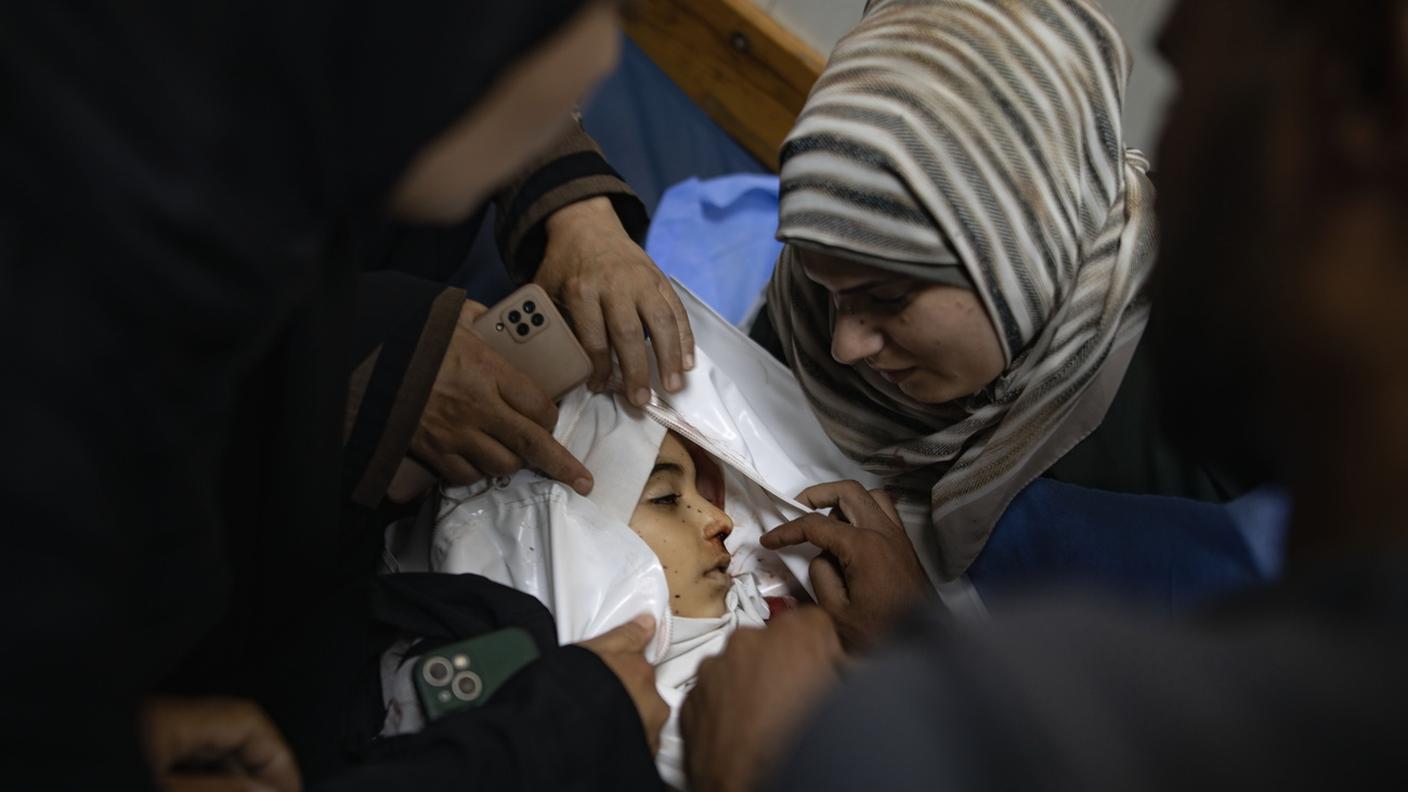 La madre della piccola Julie Al-Balawi, di otto anni, accanto al corpo della figlia all’interno dell’ospedale Nasser di Khan Yunis il 21 giugno 2026, dopo un attacco israeliano sulla spiaggia