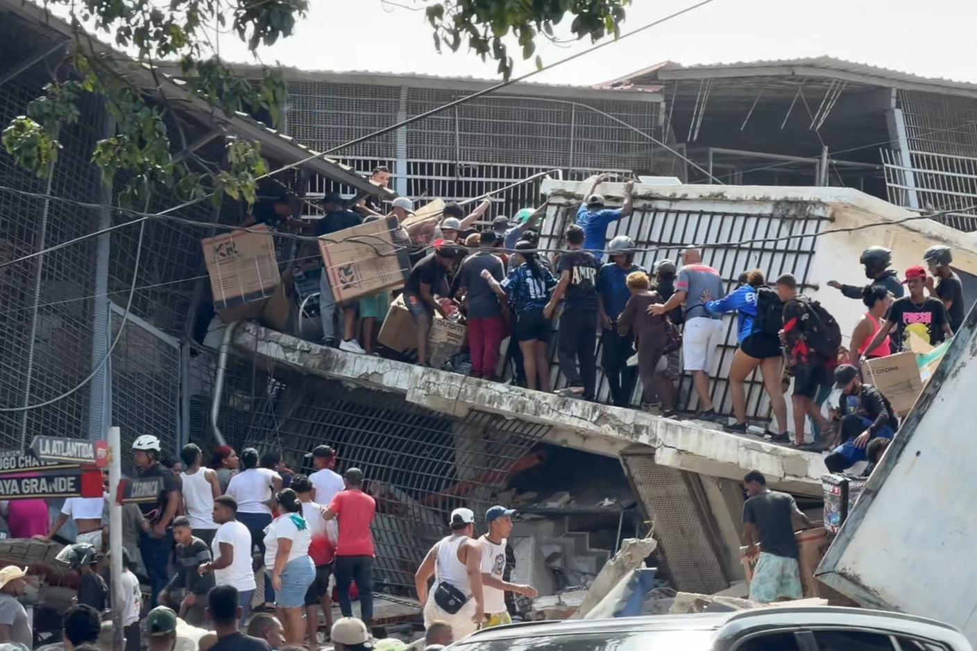 Saccheggi dopo il terremoto: qui fra le macerie di un negozio crollato in una località dello Stato di La Guaira