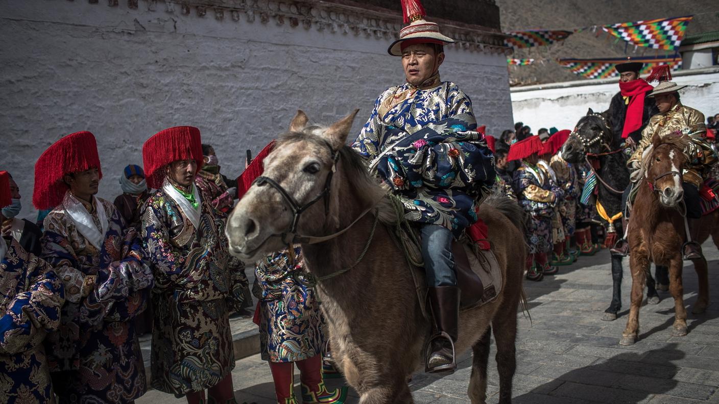 Buddisti tibetani in abiti tradizionali partecipano a una cerimonia durante il Festival della Grande Preghiera di Monlam al monastero di Labrang
