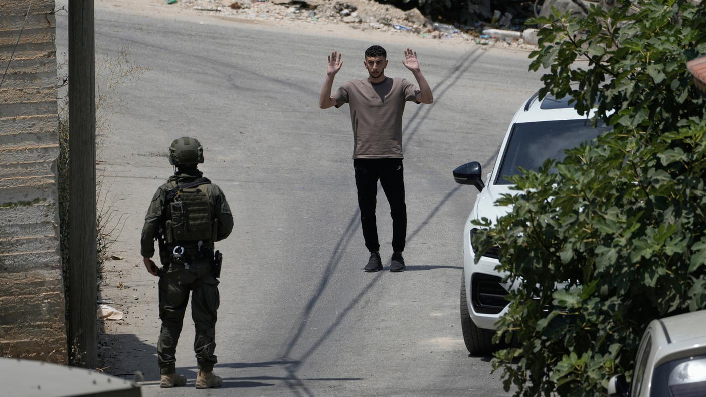 Un soldato israeliano interroga un palestinese durante un'operazione militare nel villaggio di Tell, vicino a Nablus, Cisgiordania. 25 luglio 2026