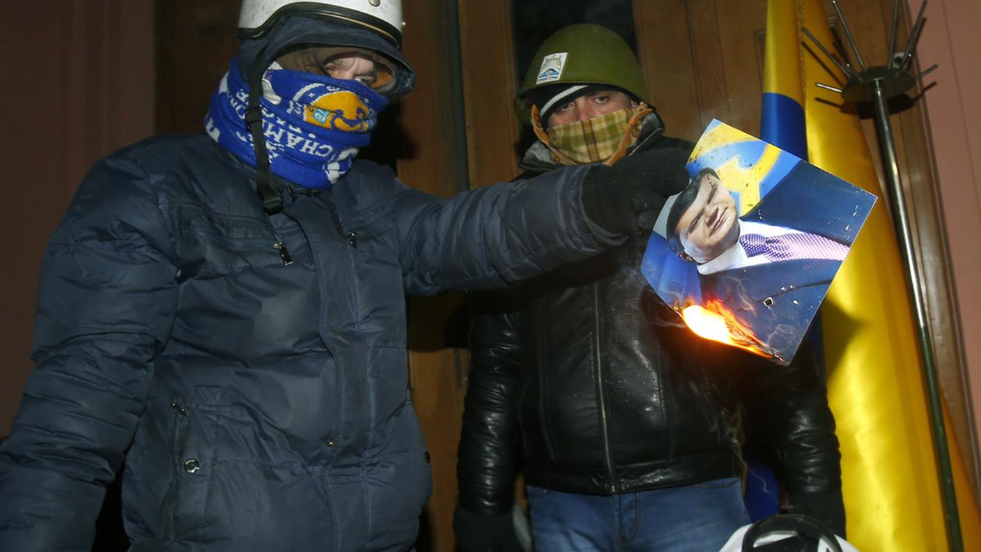 Oppositori di Ianukovich danno alle fiamme una foto del presidente ucraino