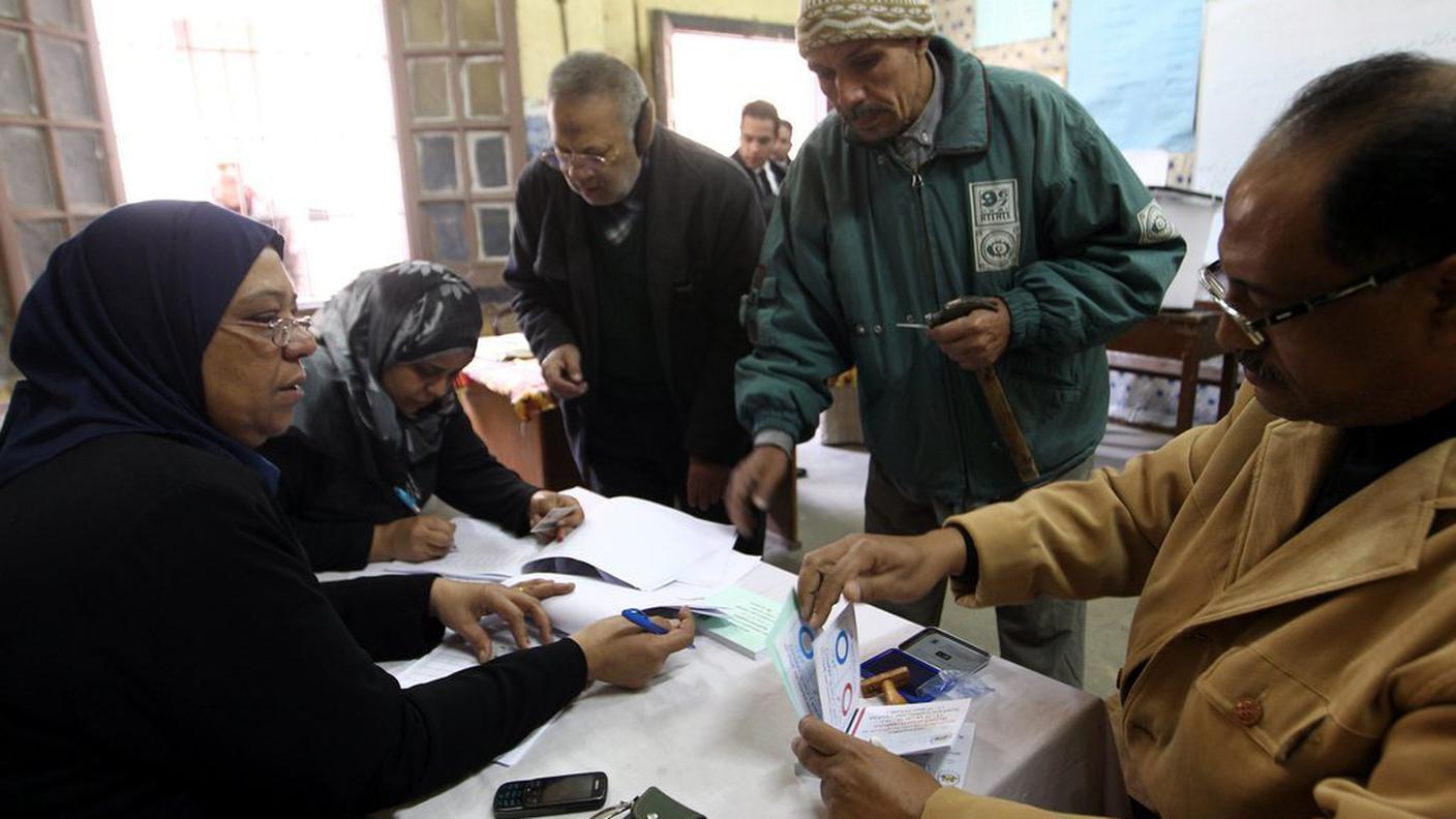 Procedure di registrazione dei votanti martedì in un seggio al Cairo